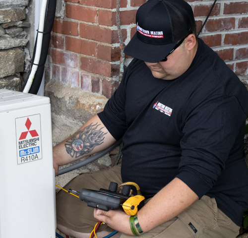 Hometown Heating technician checking coolent levels in AC compressor