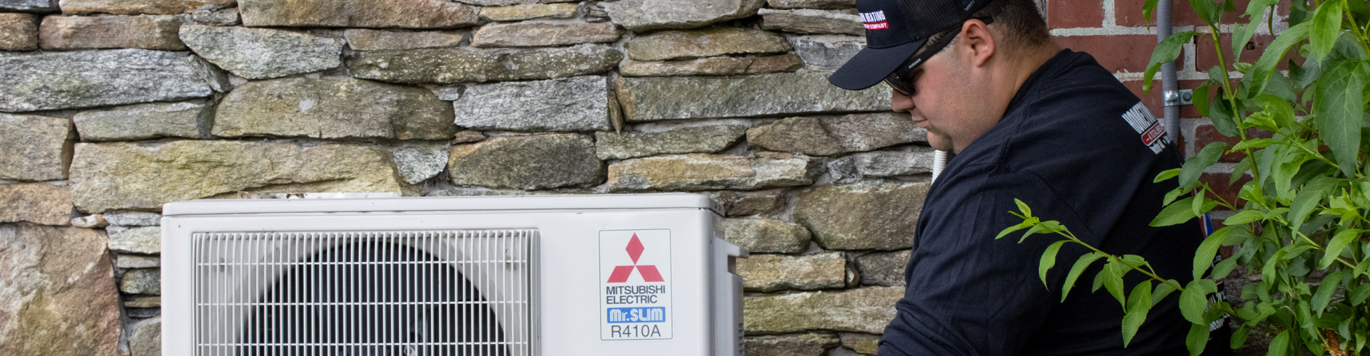 Hometown Heating technician performing maintenance on a ductless AC unit