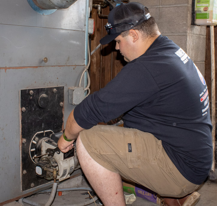 Hometown Heating technician performing maintenance on a gas fired furnace