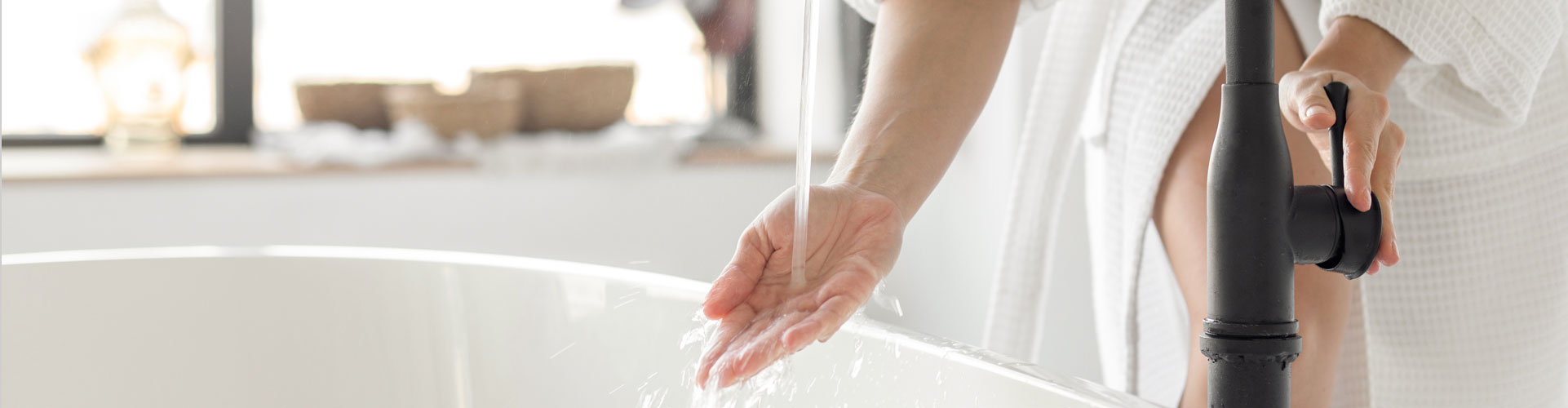 Woman drawing a bath with warm water supplied by a Hometown Heating installed hot water heater